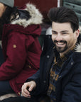 couple sitting on a bench wearing winter jackets with fur hood