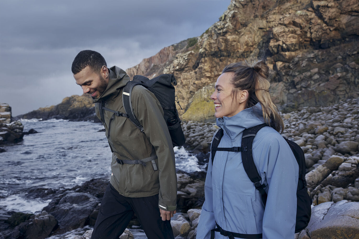 couple hiking on rocky coast