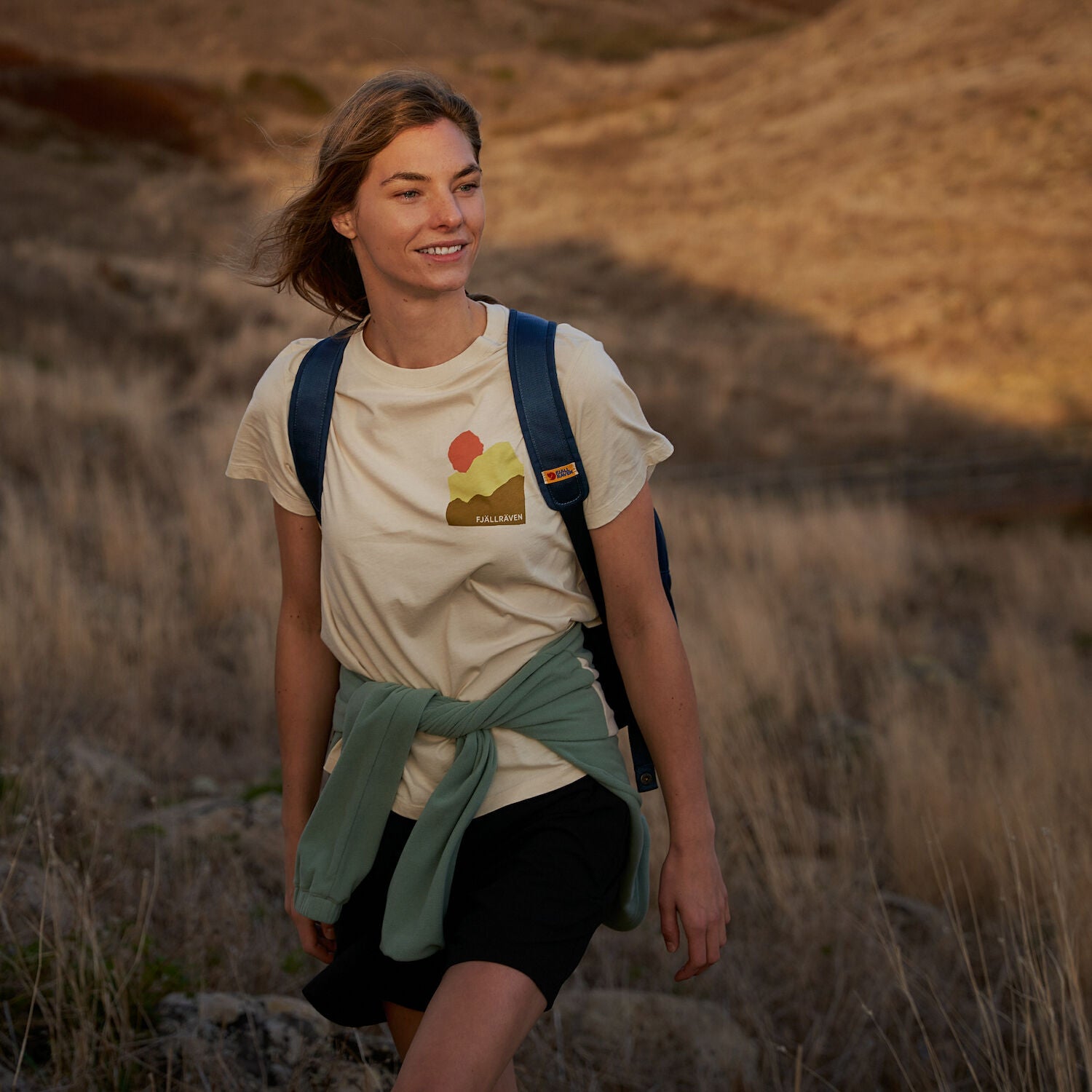 woman in white t-shirt trekking on grass patch