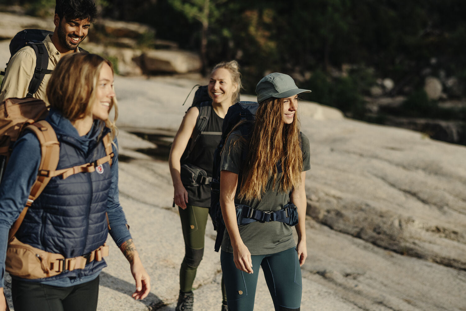 women carrying trekking backpack and wearing t-shirts and winter jackets on a trek