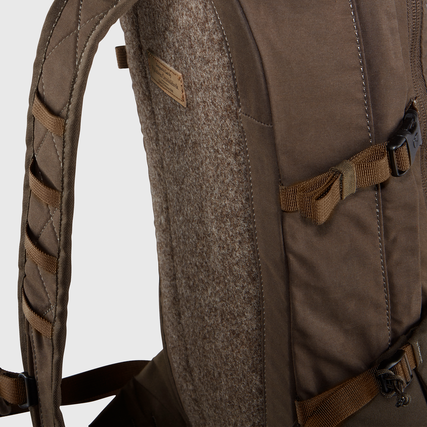 Close-up of a brown backpack with straps on a light gray background
