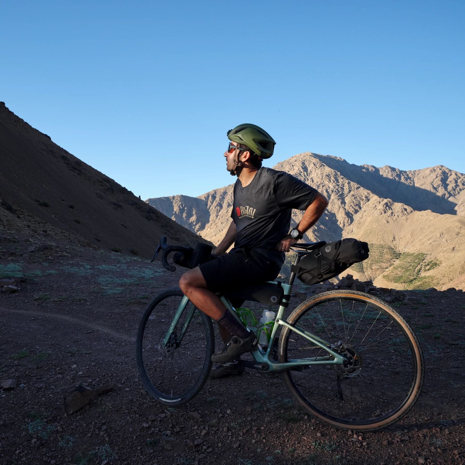 Man with a bicycle in a mountainous desert landscape