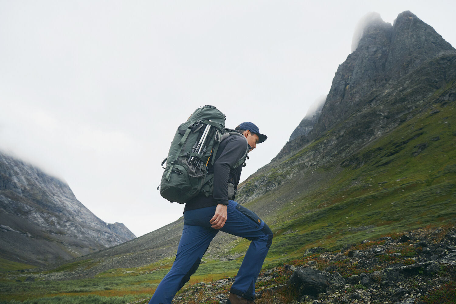 men carrying trekking backpack climbing mountain