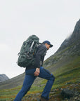 men carrying trekking backpack climbing mountain