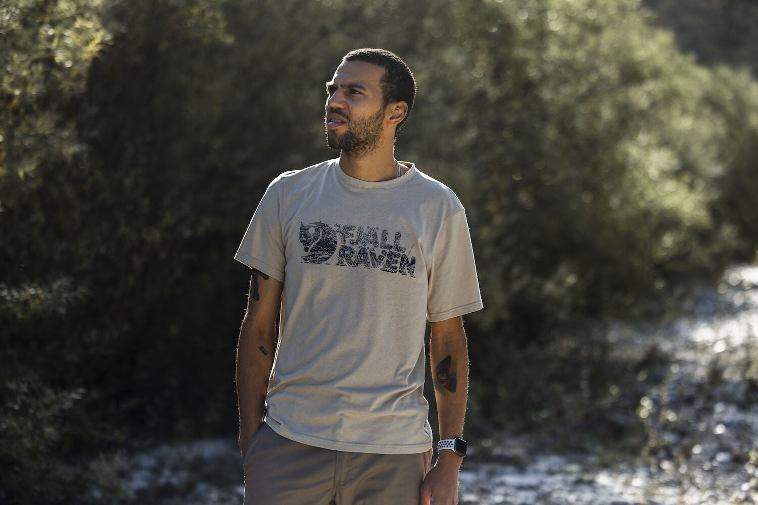man wearing fossil round neck t-shirt  on a rocky mountain