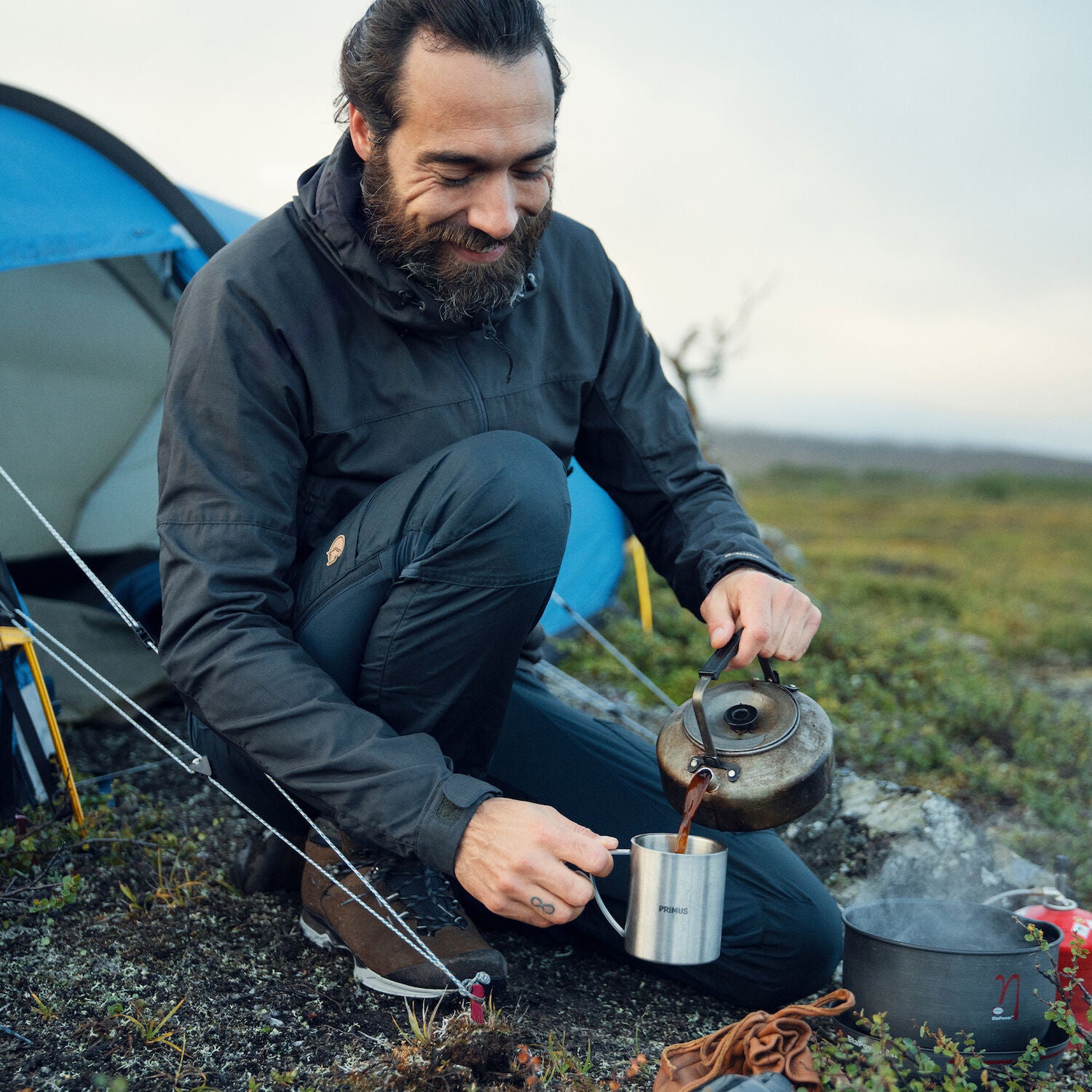 man pouring coffee on a hiking camping trip