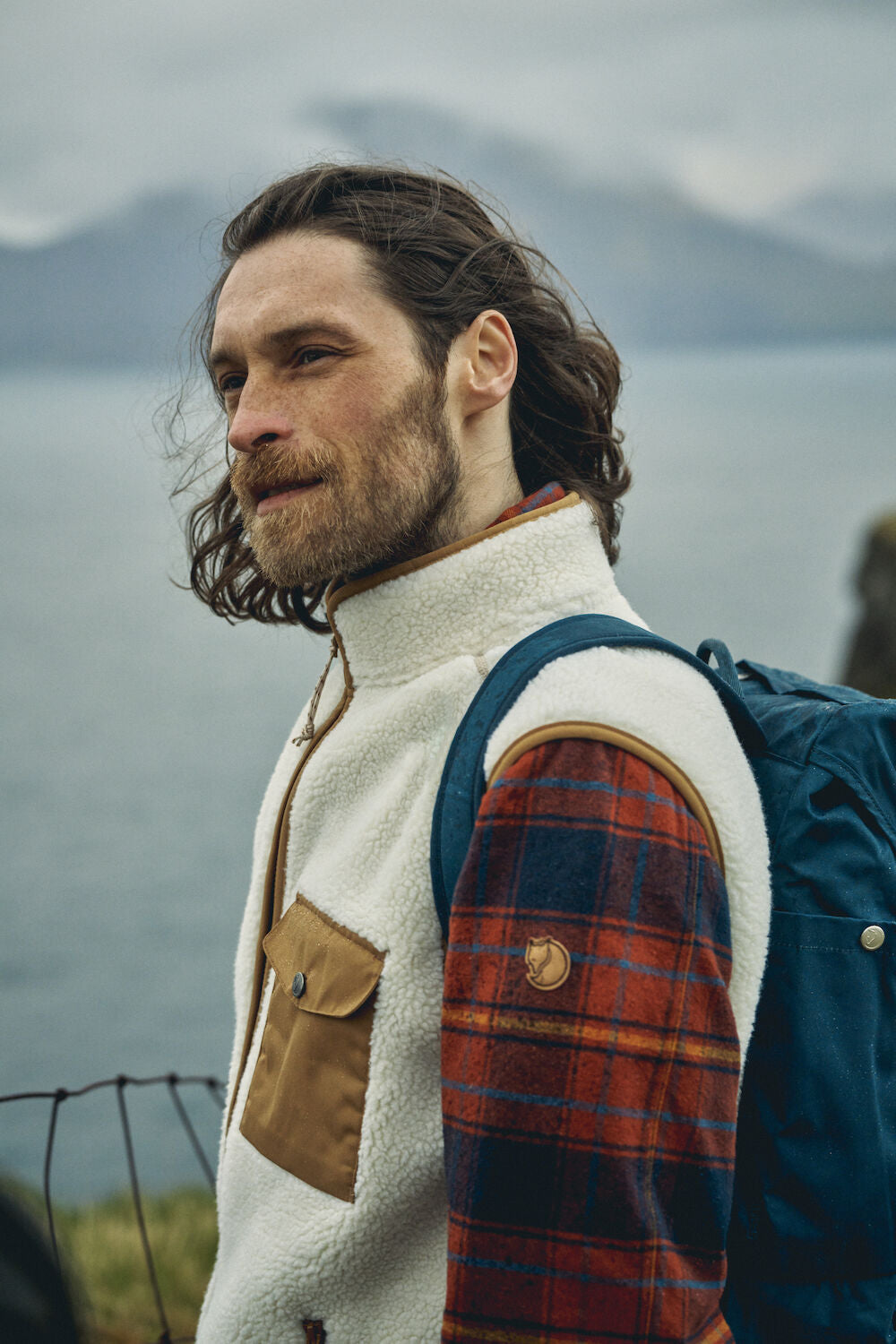 man wearing white vest over a checkered shirt