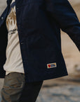 man wearing white shirt and navy outerwear with Fjällräven logo