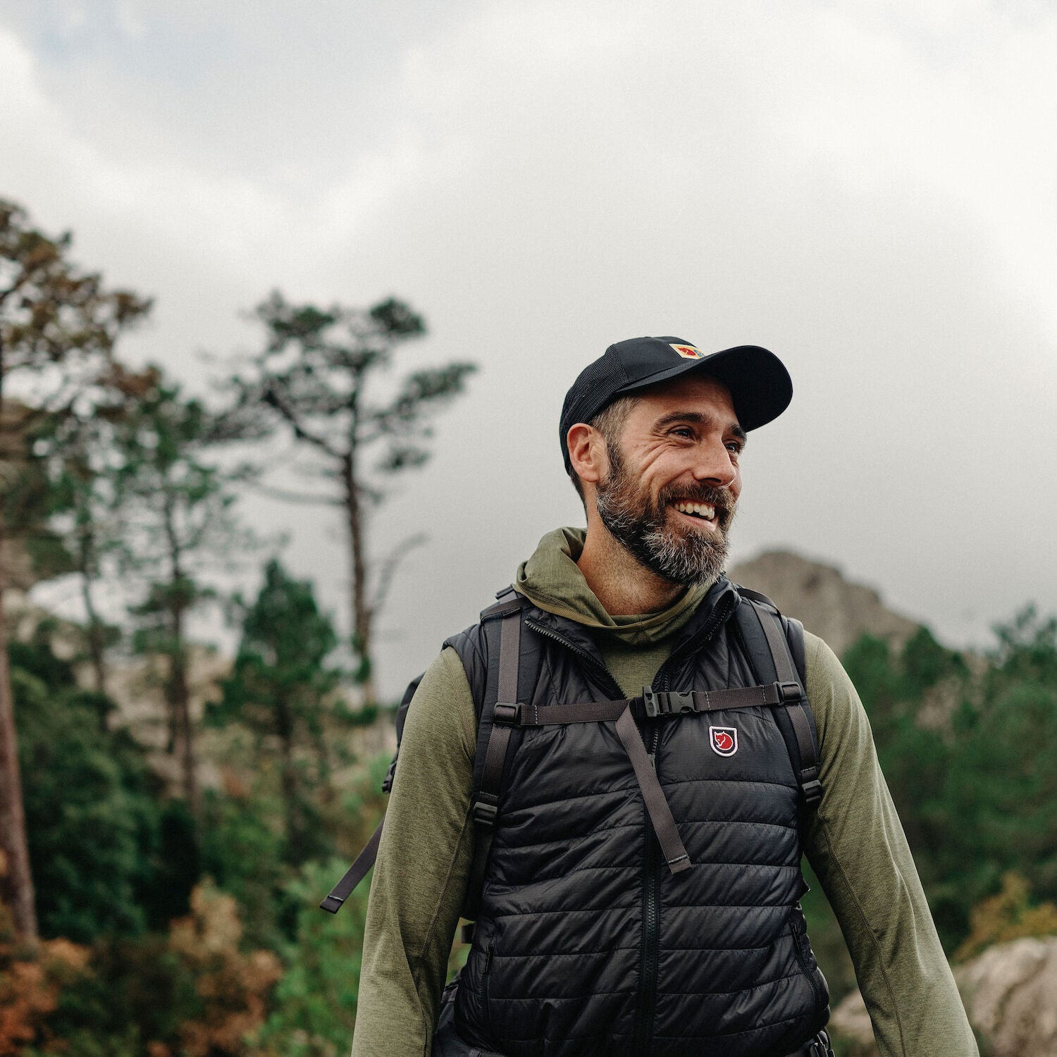man wearing green sweater hoodie with black vest