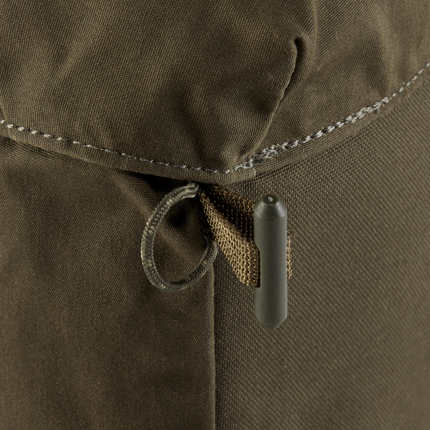 Close-up of a brown fabric with a drawstring and button, likely from a bag or pouch.