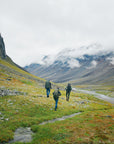 three men carrying trekking backpack trekking on a mountain