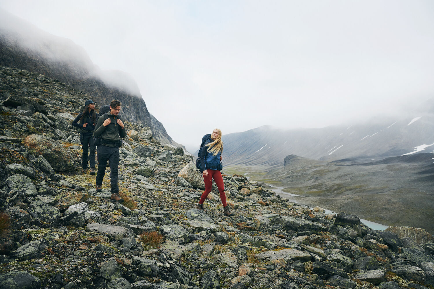 three men trekking downslope on mountain