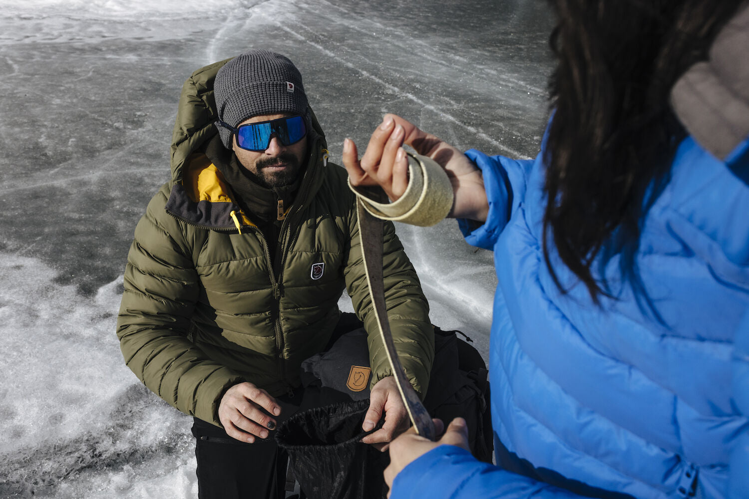 Two people in winter clothing on a frozen surface