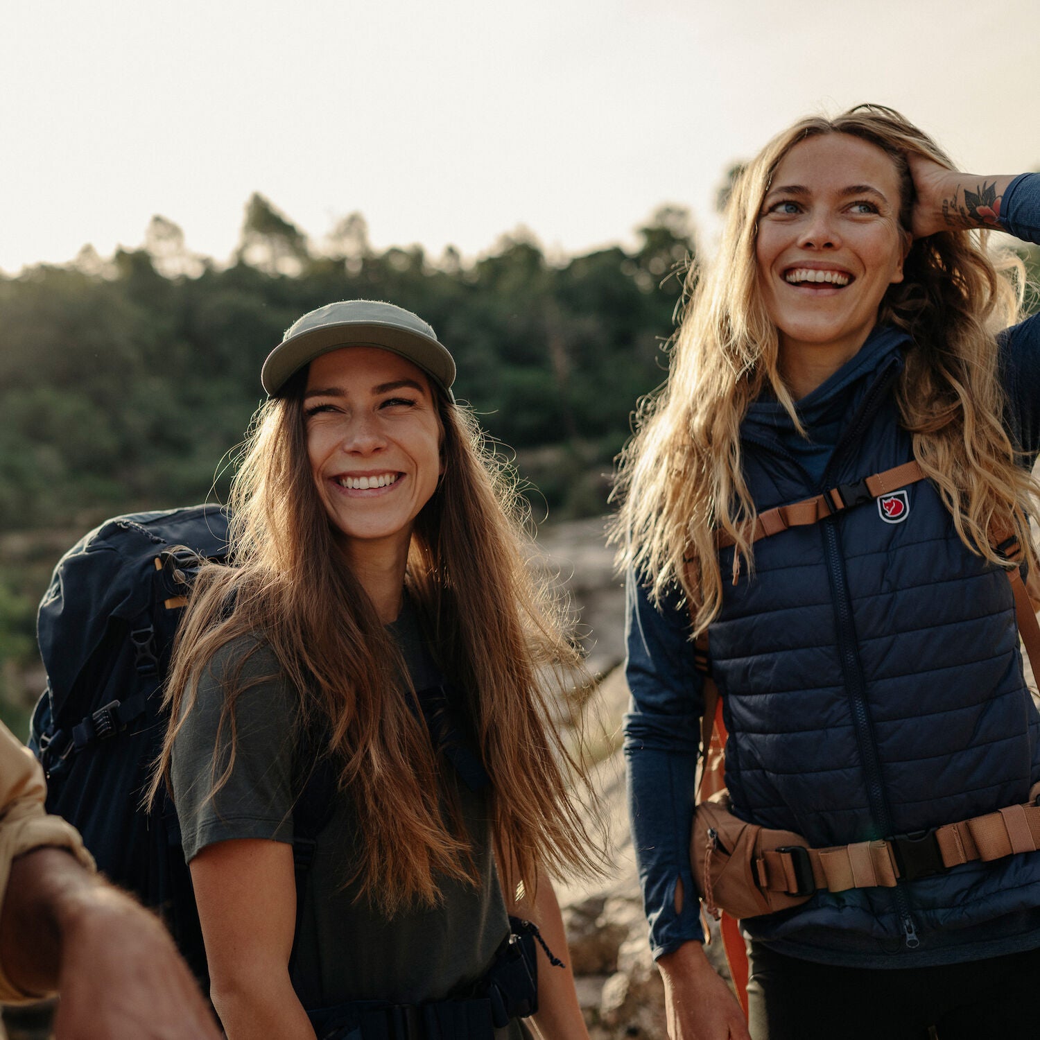 two women smiling while on a backpacking trip