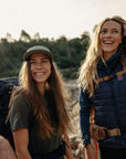 two women smiling while on a backpacking trip