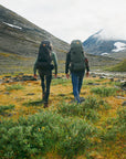 two men carrying trekking backpack trekking on a mountain