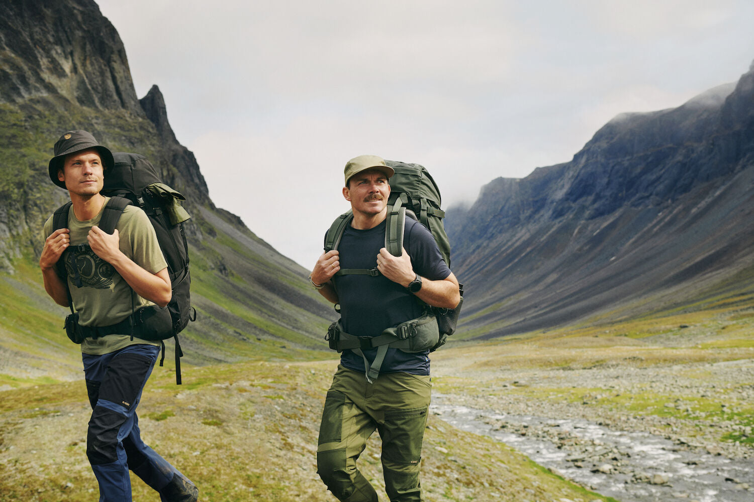 two men carrying trekking backpack trekking on a mountain