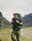 two men carrying trekking backpack trekking on a mountain