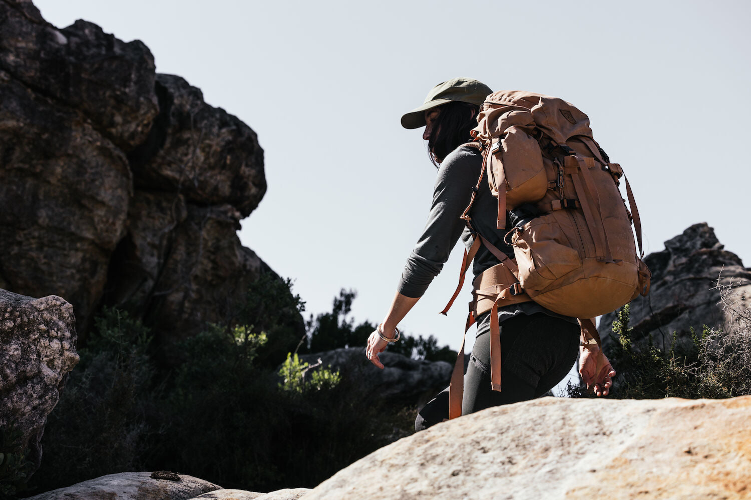 Person hiking with a large backpack in a rocky outdoor setting