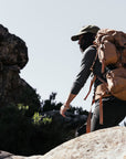 Person hiking with a large backpack in a rocky outdoor setting