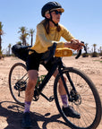Person with a bicycle in a desert landscape with palm trees