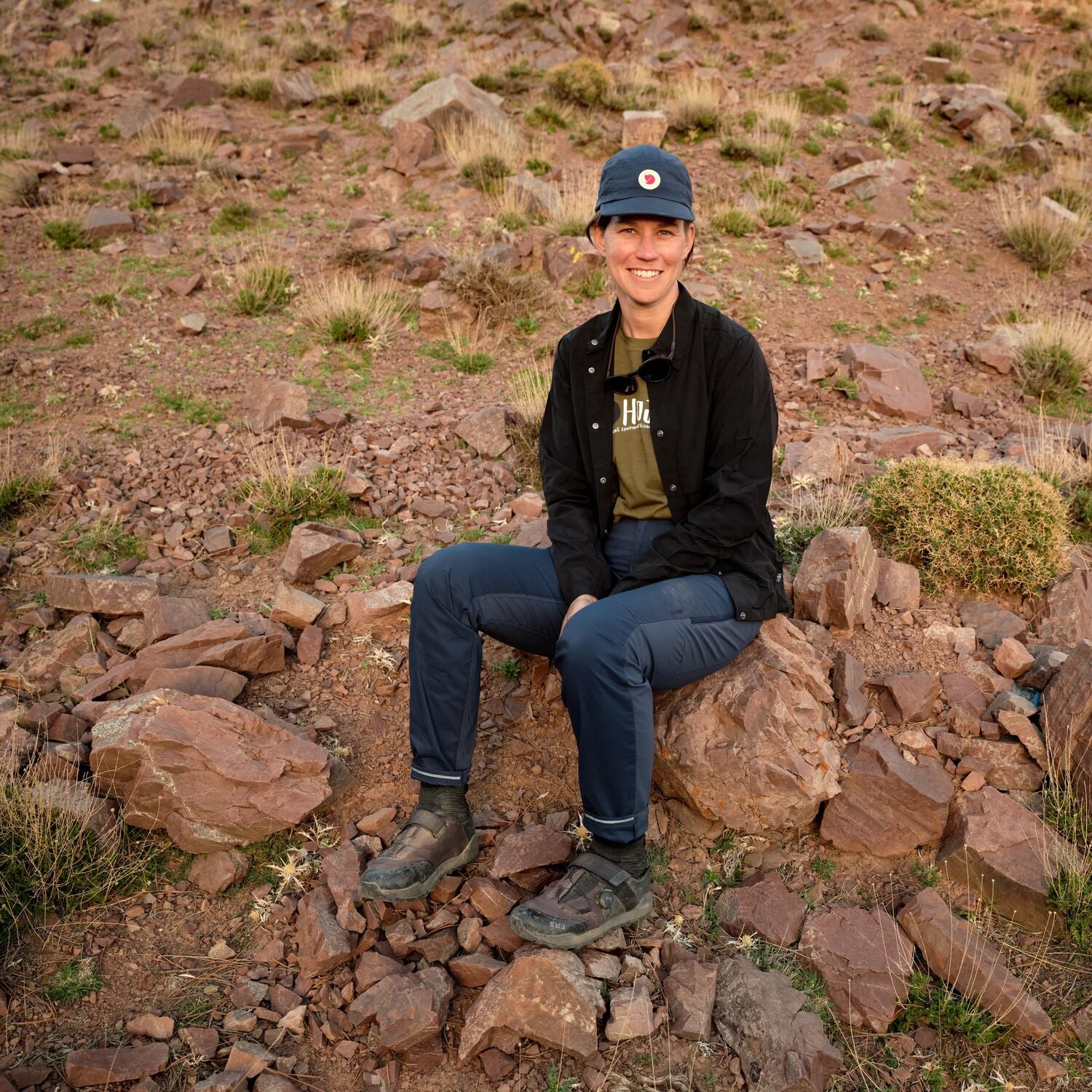 Person sitting on rocks in a desert landscape