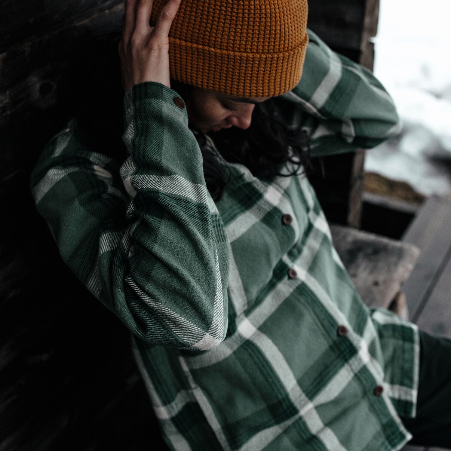 woman in patina green-deep patina  long sleeve shirt and orange beanie
